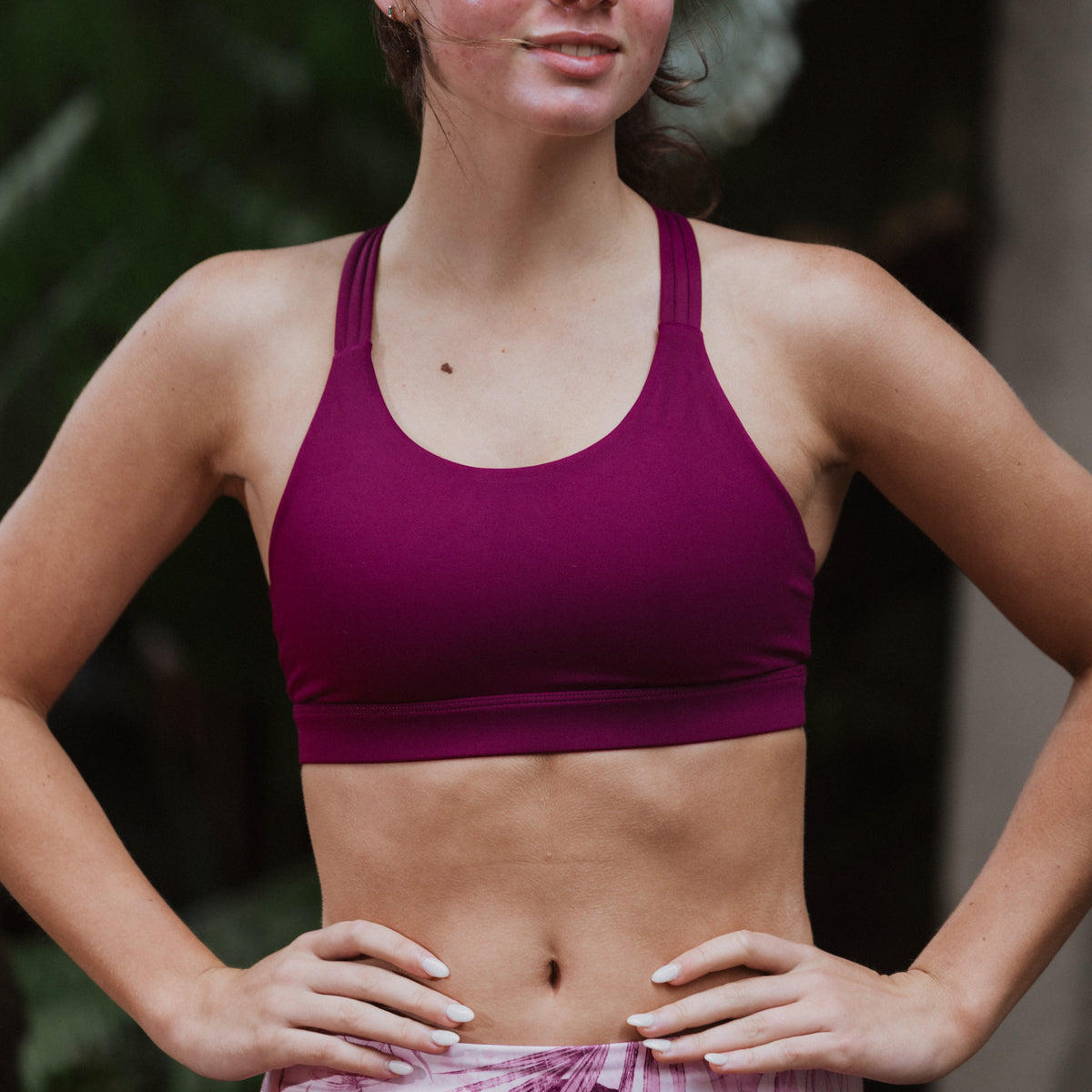 Woman wearing a purple sports bra with a blurred background